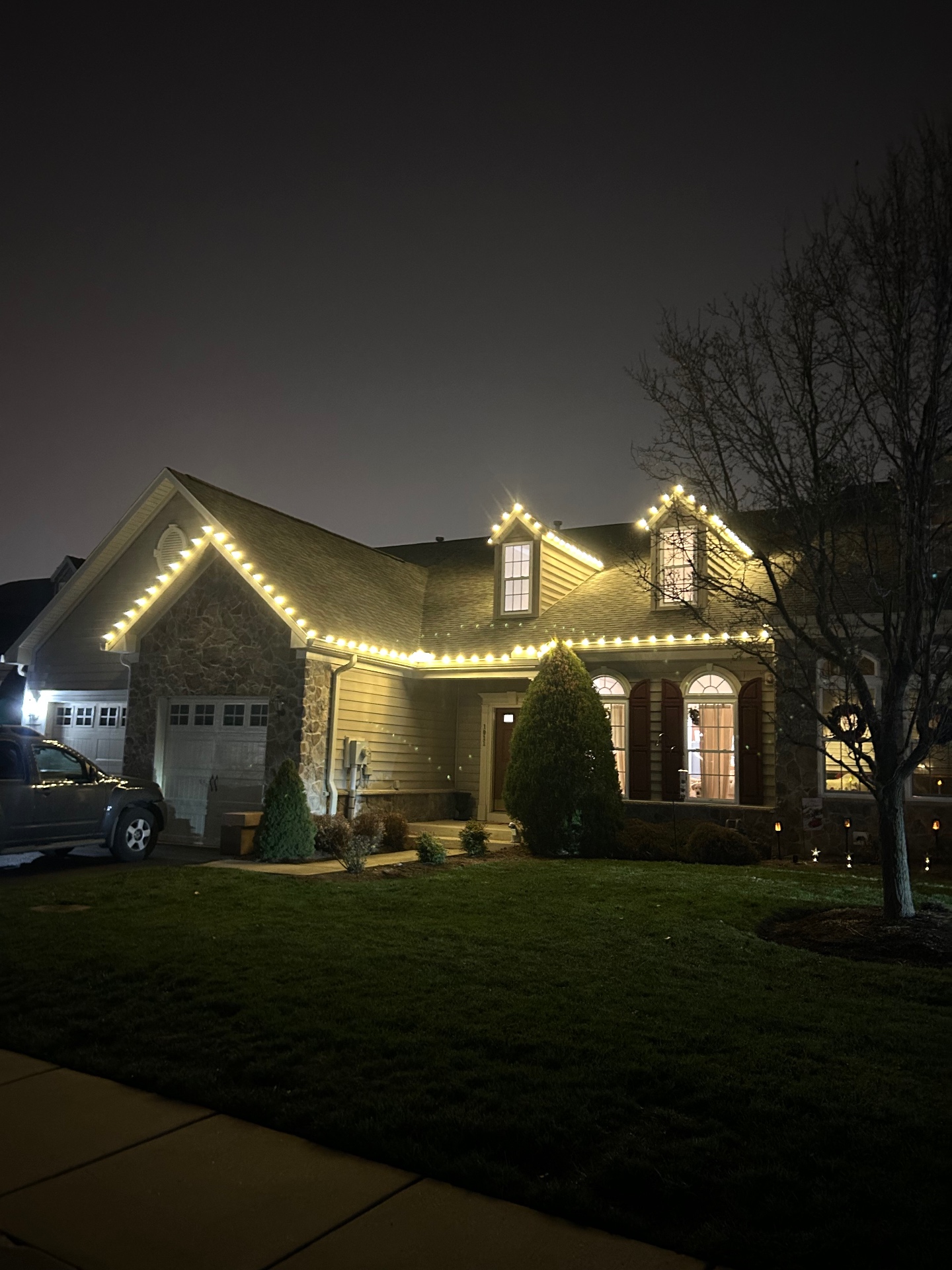 Cape cod home with warm white C9 lights on gables and dormers