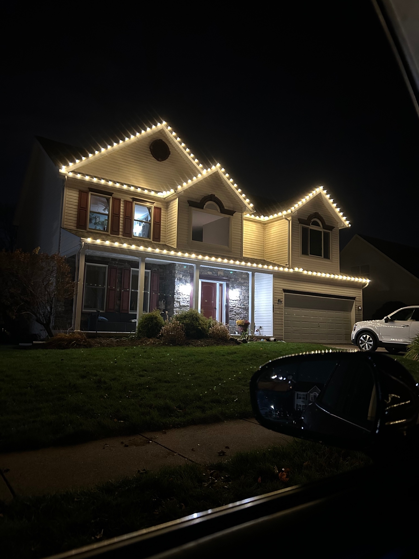 Triple-gable home with warm white C9 roofline Christmas lights